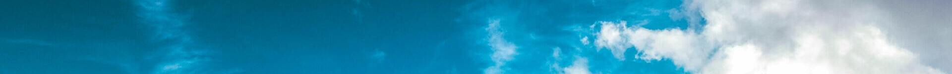 A horizontal banner depicting a brilliant, bright sky with clouds.